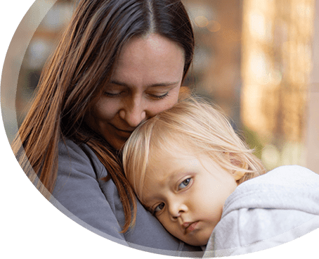 Liebevolle Mutter mit müdem Kind im Arm